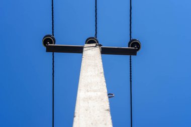 Mavi gökyüzüne karşı bir elektrik direği.