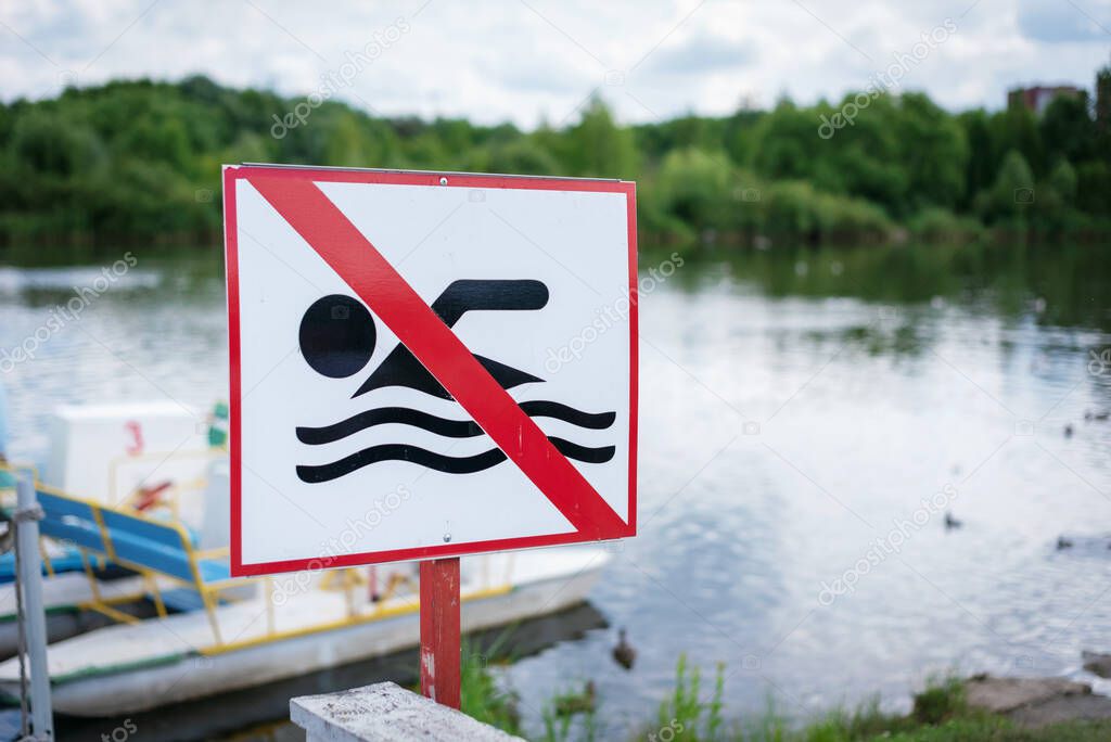 Sign swimming is prohibited on the lake shore, selective focus.