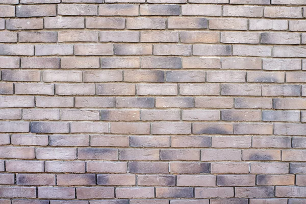 The wall is made of beige decorative bricks, background.