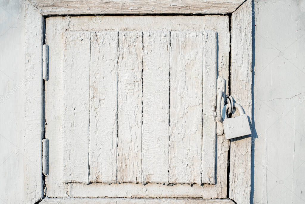 Old white wooden door with a padlock.