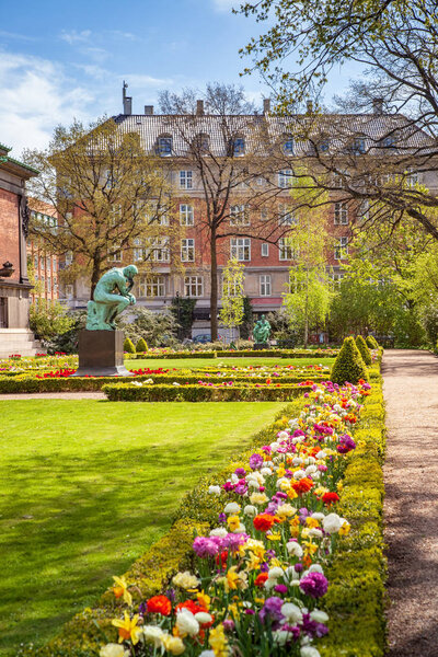 Urban scene with city park with flowers and monument in Copenhagen, denmark