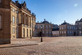 wunderschönes Schloss Amalienborg und historische Gebäude und Straßenlaternen auf einem leeren Platz in Kopenhagen, Dänemark