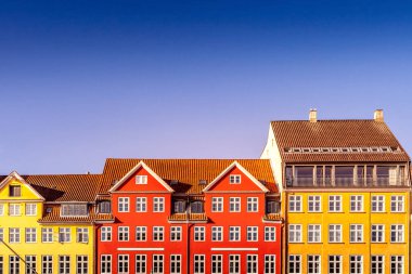beautiful colorful historical houses against blue sky in copenhagen, denmark clipart