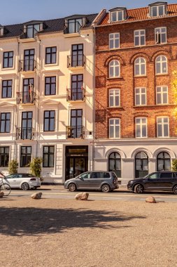 COPENHAGEN, DENMARK - MAY 6, 2018: parked cars on street in front of buildings  clipart