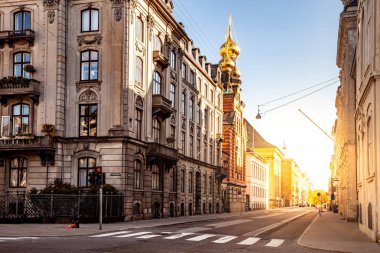 COPENHAGEN, DENMARK - MAY 6, 2018: cityscape with buildings and church with sunlight clipart
