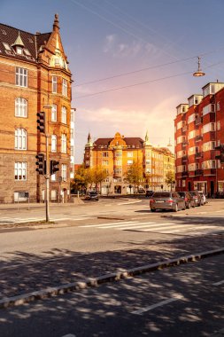 COPENHAGEN, DENMARK - MAY 6, 2018: cityscape with buildings, street and cars  clipart