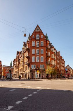 COPENHAGEN, DENMARK - MAY 6, 2018: cityscape with buildings and people walking on street in Copenhagen, Denmark clipart