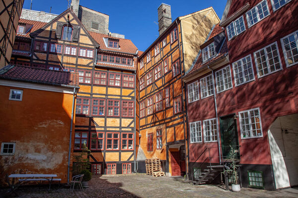 low angle view of beautiful historical houses against blue sky and cozy empty yard in copenhagen, denmark