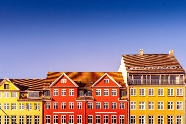 beautiful colorful historical houses against blue sky in copenhagen, denmark