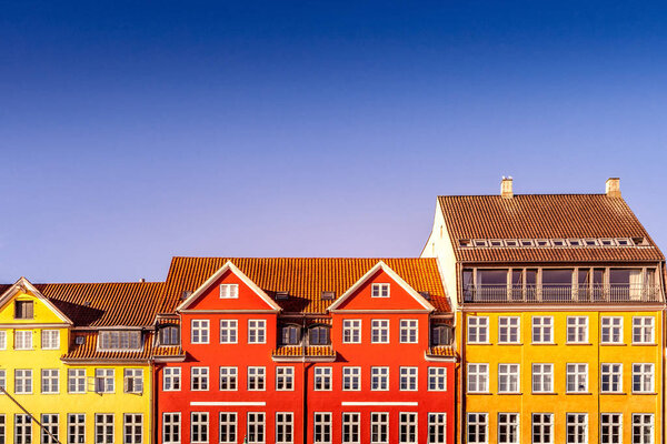 Beautiful colorful historical houses against blue sky in copenhagen, denmark