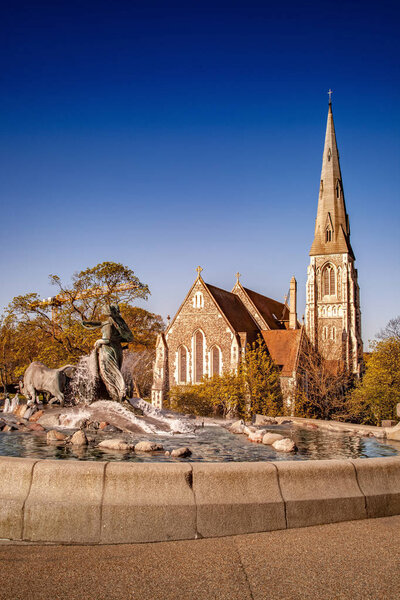 historical statue and fountain near beautiful church in copenhagen, denmark