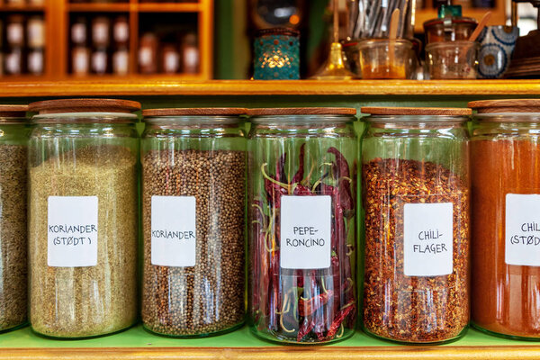 close up image of different spices in jars placed in row