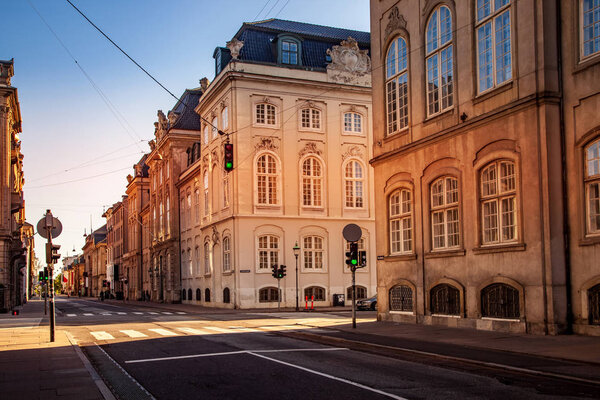 КОПЕНГАГЕН, ДЕНМАРК - 6 мая 2018 года: живописный вид на городской пейзаж со зданиями и пустой улицей
 
