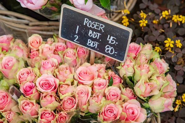 Close-up tiro de flores de rosa e giz bordo com letras em cesta de vime — Fotografia de Stock