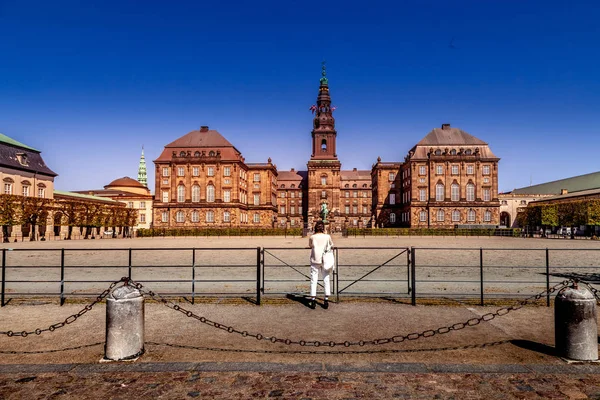 COPENHAGEN, DINAMARCA - 6 DE MAYO DE 2018: vista trasera de la mujer tomando fotos del palacio Christiansborg - foto de stock