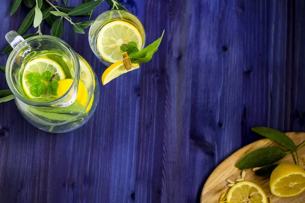 refreshing drink with lemon, mint and sage on a blue background