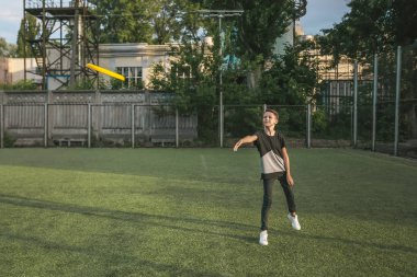 yeşil çimenlerin üzerinde uçan disk atma çocuk görünümünü tam uzunlukta
