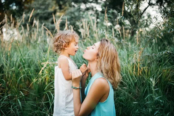 Side View Mother Going Kiss Daughter Squatting Grass Royalty Free Stock Photos