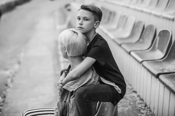 Black and white photo of mother and son hugging on stadium — Stock Photo