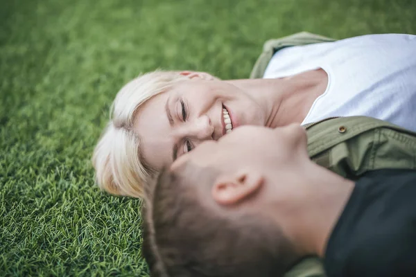 Nahaufnahme einer glücklichen Mutter und ihres Sohnes, die zusammen im Gras liegen, selektiver Fokus — Stockfoto