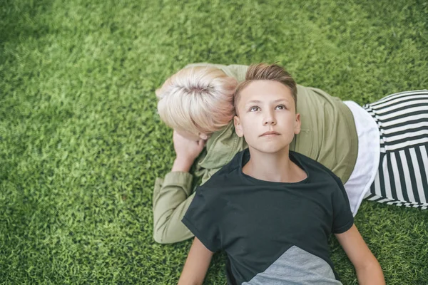 Von oben: Mutter und Sohn liegen zusammen auf grünem Gras — Stockfoto