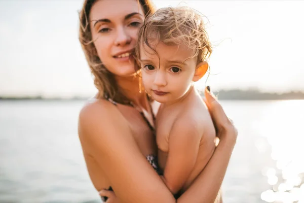 Madre e bambino guardando la fotocamera nel fiume — Foto stock