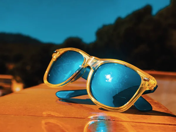 Mavi cam ayna gözlük, turuncu bir evle geri bulanık manzara