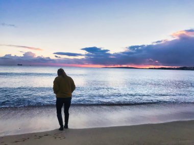 kışın gün batımında denize bakan kız