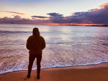 kışın gün batımında denize bakan kız