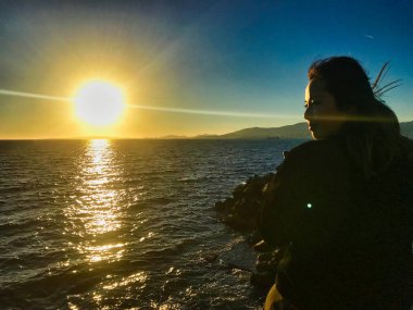 deniz kenarında telefon ile oynayan güzel asyalı kız