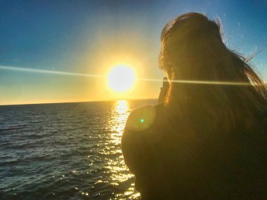 deniz kenarında telefon ile oynayan güzel asyalı kız