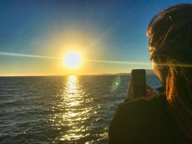 deniz kenarında telefon ile oynayan güzel asyalı kız