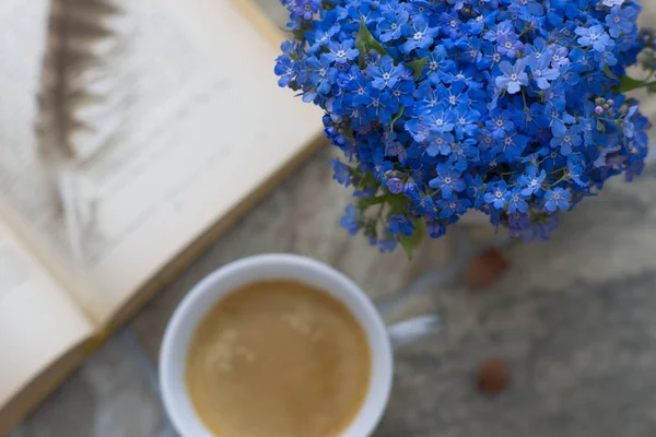 Cup of coffee, a book and flowers, morning serenity