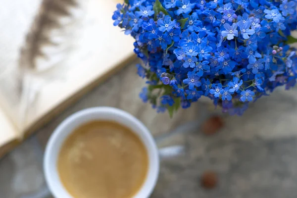 Cup of coffee, a book and flowers, morning serenity