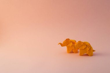 Origami filleri yeşil arka planda renkli kağıtlardan yapılmıştır. Kağıt ve orman koruma kavramı. Aile ve çocukluk. Mockup, boşluğu kopyala.