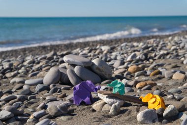 Sahilde çakıl taşları üzerinde duran renkli origami filleri..