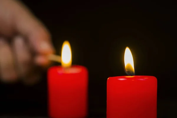 Borrosa Fondo Una Mano Encendiendo Velas Rojas —  Fotos de Stock