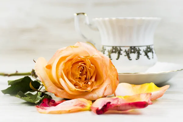 白い背景の飾りとカップの背景に明るい赤いバラ — ストック写真