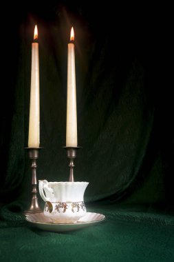 Yeşil bir bez karşı bir retro Kupası şamdanla içinde yanan mum