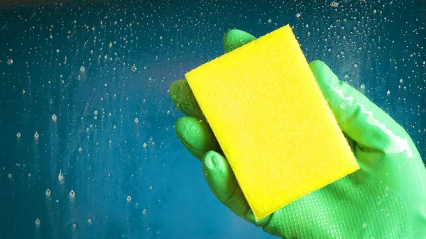 Hand Grünem Handschuh Mit Einem Gelben Schwamm Auf Blauem Hintergrund — Stockfoto