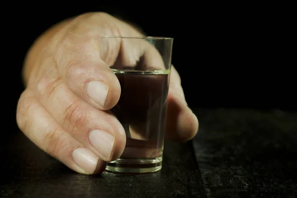 Ein Schuss Wodka Der Hand Auf Schwarzem Hintergrund — Stockfoto