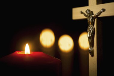 Siyah bir zemin üzerine tahta haç yanan mumlar ile