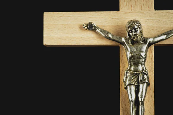 Fragmento Crucifixo Iluminado Marrom Claro Madeira Contra Fundo Preto — Fotografia de Stock