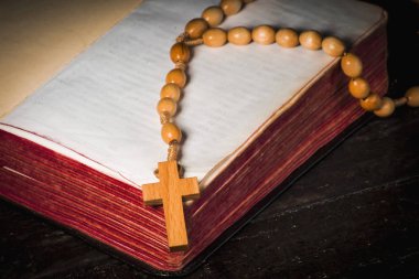Eski kurullarında açık bir kitap arka plan üzerinde tespih