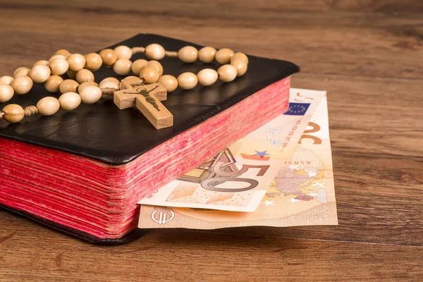ユーロ紙幣を本の背景ボードに横たわっているロザリオ — ストック写真