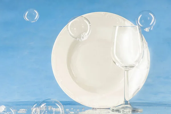 Um prato e um copo sobre um fundo azul — Fotografia de Stock