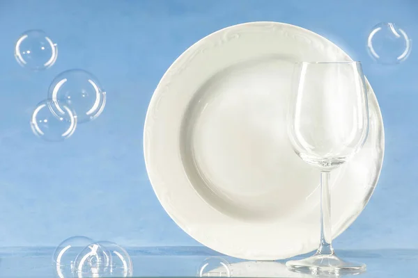 Une assiette et un verre sur fond bleu — Photo