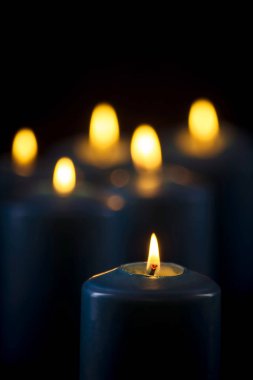 Siyah bir arka plan üzerinde yanan mavi mumlar