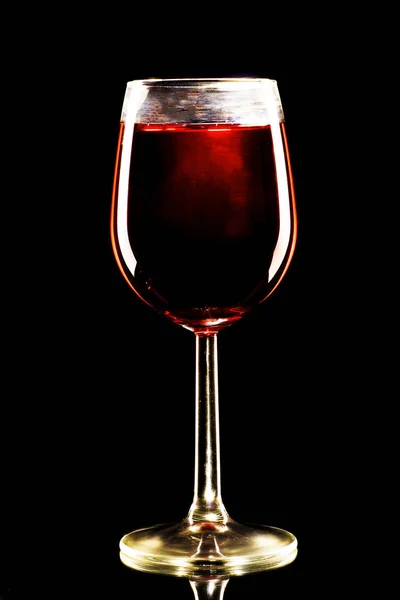 Um copo de álcool vermelho sobre um fundo preto — Fotografia de Stock