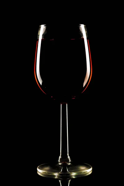 Um copo de álcool vermelho sobre um fundo preto — Fotografia de Stock
